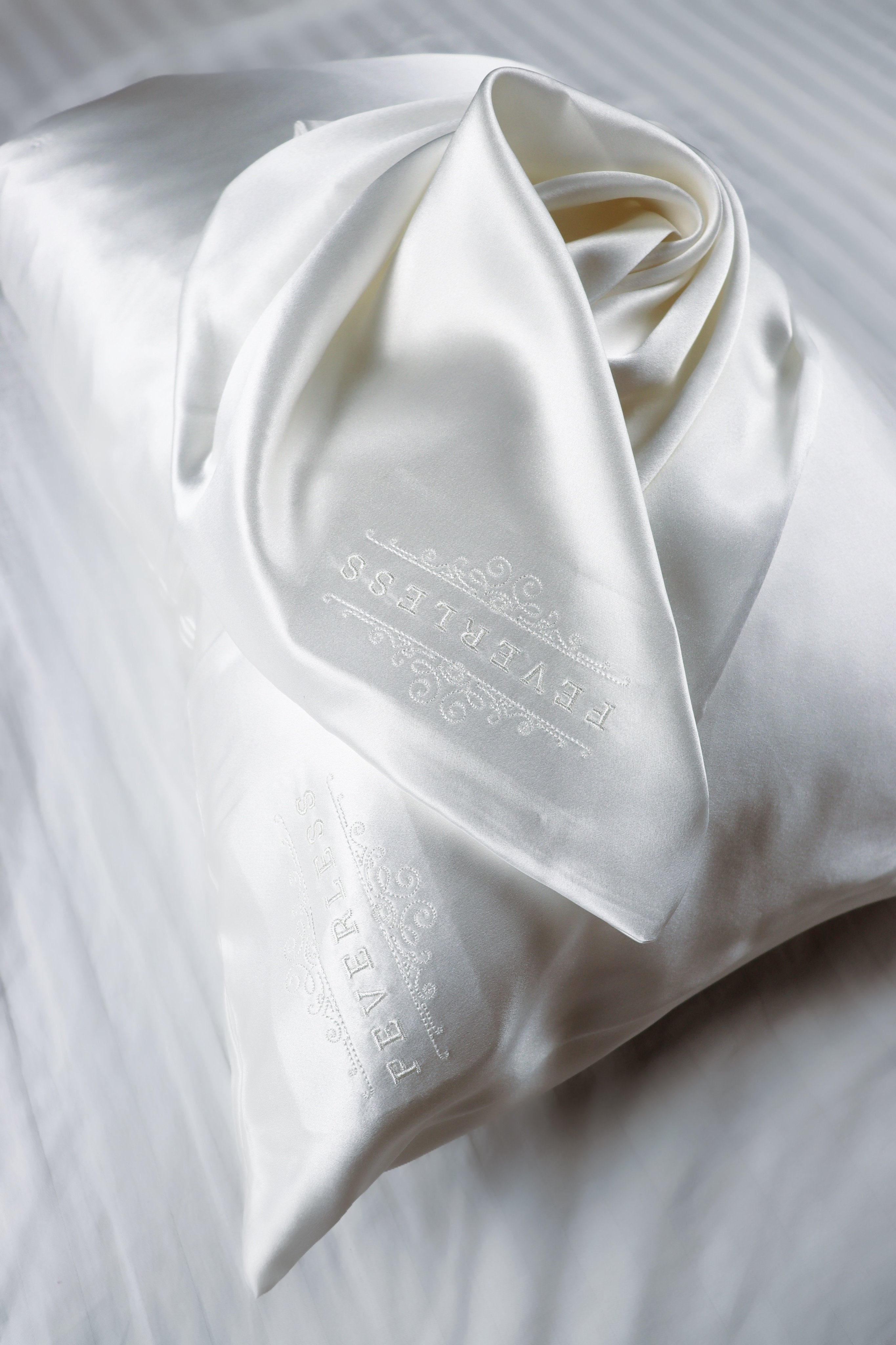 SET de 2 fundas de almohada bordadas con el logo FeverLess, de Seda Natural Mulberry con cierre Blanco SET de 2 fundas de almohada bordadas con el logo FeverLess, de Seda Natural Mulberry con cierre Blanco