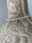 Adela necklace at the base of the neck with pearls by Shirley Navone with gold-plated metal details.