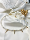 Adela necklace at the base of the neck with pearls by Shirley Navone with gold-plated metal details.