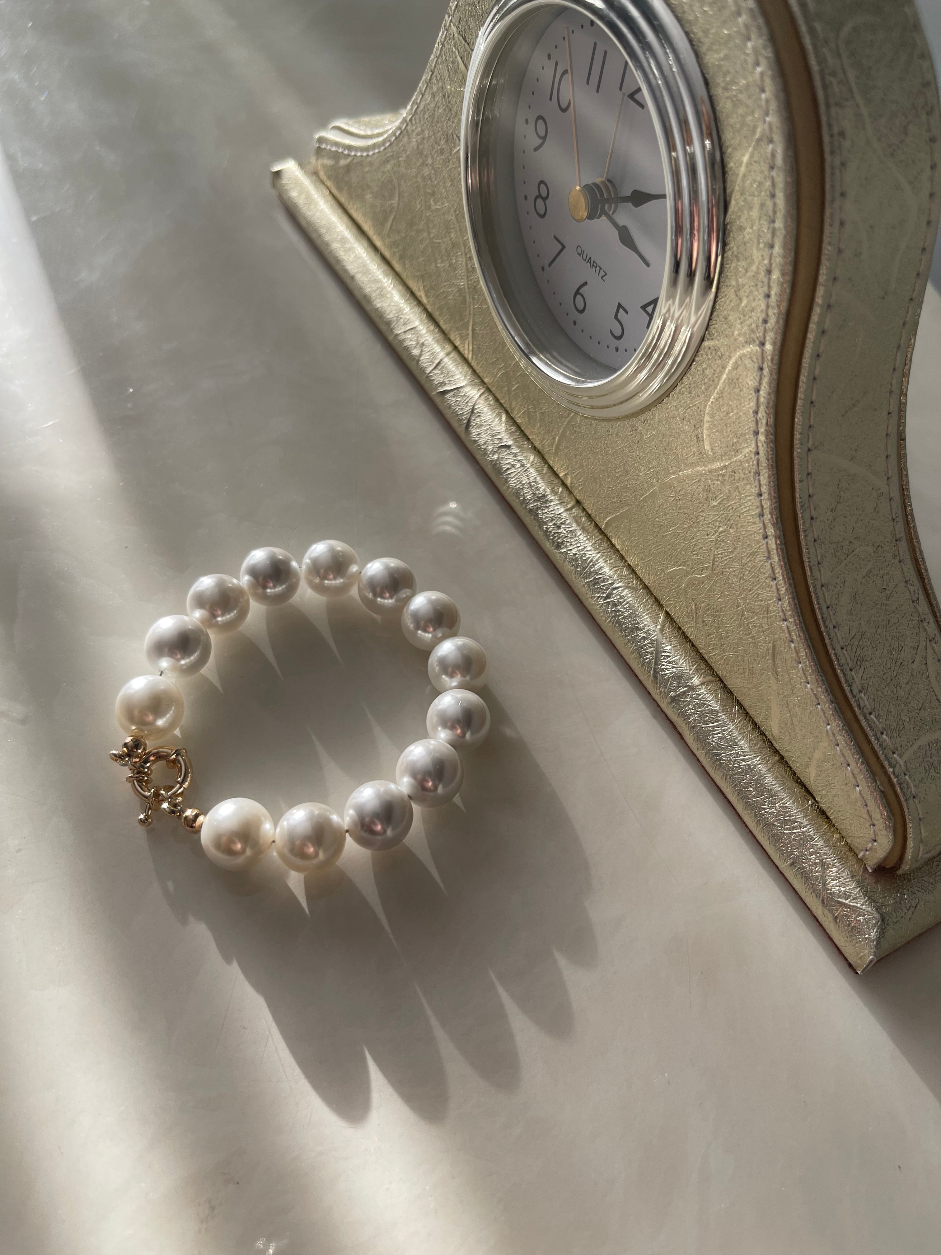 Seashell Pearl Bracelet by Shirley Navone with gold-plated metallic details.